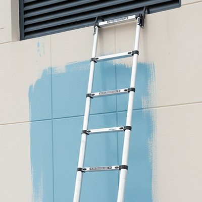 Echelle telescopique accrochée au rebord d'ouverture murale