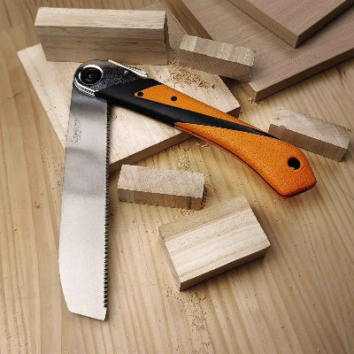 Scie japonaise pliantesur une table avec des pièces de bois