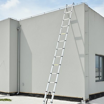 Echelle telescopique accrochée au toit d'un bâtiment