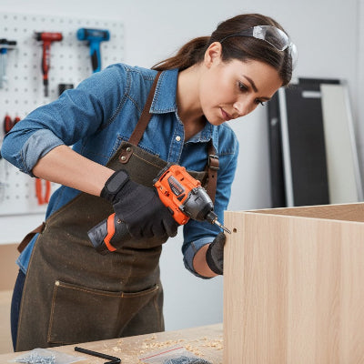 Femme utilisant la visseuse professionnelle pour assembler un meuble