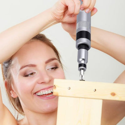 Femme utilisant le tournevis à frapper pour dévisser une vis d'un meuble