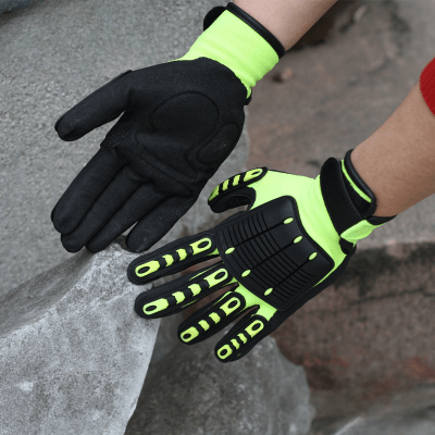 On voit les mains d'Un homme avec ses gants de travail jaune dans un endroit qui semble être une carrière de roches