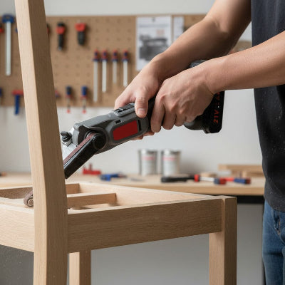 Hommeponçant les barreaux d'une chaise en bois avec une ponceuse a bande sans fil 
