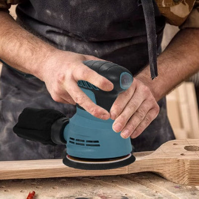 Homme utilisant la ponceuse excentrique bleue sur bois