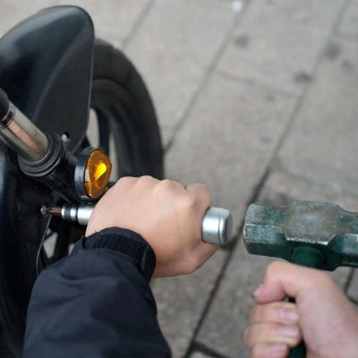 Homme utilisant le tournevis à frapper pour déloger une vis dans métal