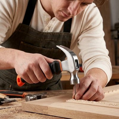 Marteau utilisé par homme pour clouer moulure