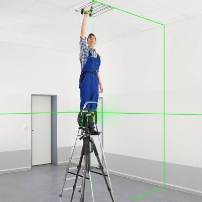 Niveau laser installé sur trépied et homme sur un escabeau