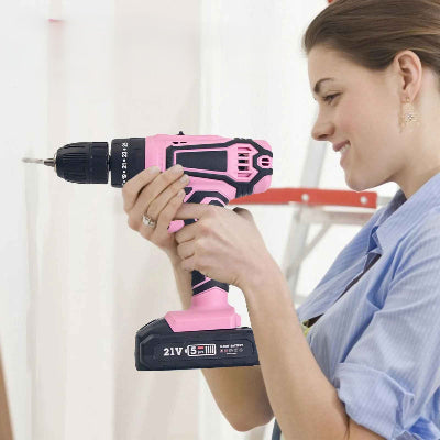 Perceuse visseuse  légère rose en mode perceuse utilisée par une jeune femme