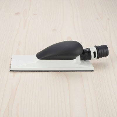 Ponceuse avec aspirateur sur fond bois pâle