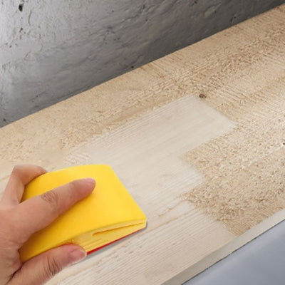 Ponceuse ergonomique utilisée pour poncer une planche