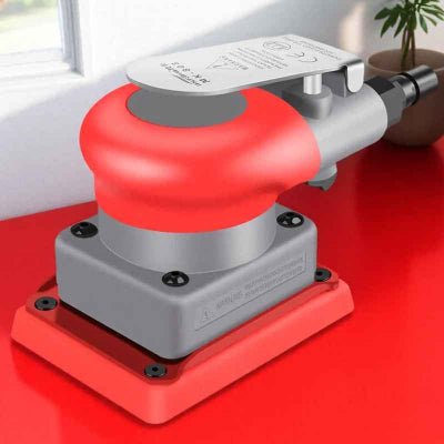 Ponceuse pneumatique carrée sur une surface au sol orange