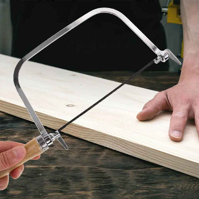 Scie à chantourner manuelle utilisée pour découper une planche de bois