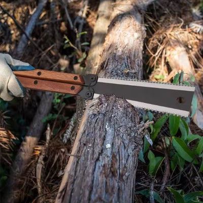 Scie pliante utilisée por couper le tronc d'un arbre