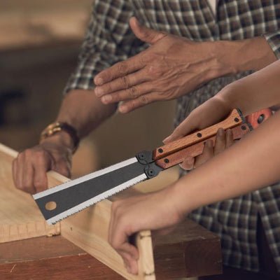 Scie pliante utilisée pour couper une planche en atelier de menuiserie