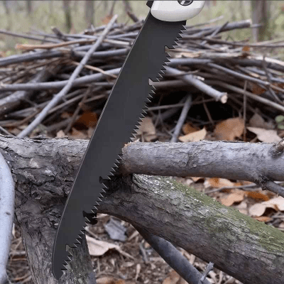 Scies à élaguer pliante blanche utilisée pour couper des branches dans la forêt