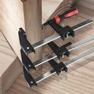 Serre joint rouge et noir fixant pièces de bois